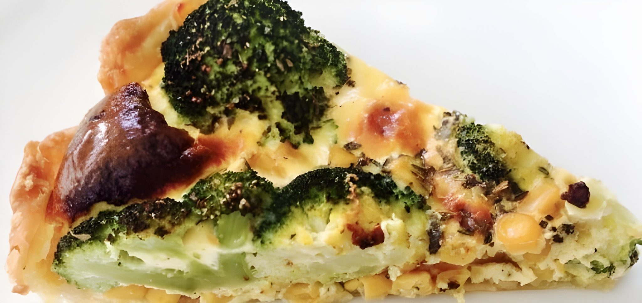 Close-up van een punt broccoli mais quiche met knapperige korst