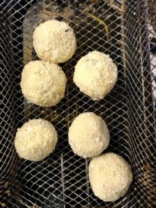 Risottoballetjes rollen en paneren met bloem, ei en panko